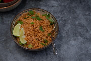 Authentic Mexican Spanish rice in ceramic bowl against gray table, copy space