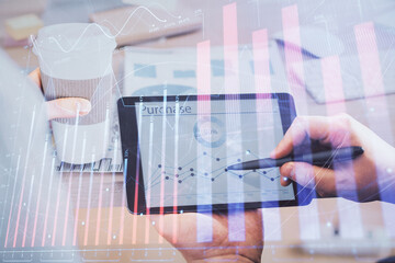 Double exposure of man's hands holding and using a phone and financial chart drawing. Market analysis concept.