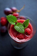 Fresh smoothie in a glass. Dark background. Close up.	