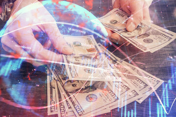 Multi exposure of financial graph drawing hologram and USA dollars bills and man hands. Analysis concept.