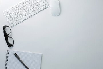 Glasses keyboard mouse notepad and pen on white background