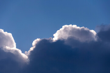 Dark and light clouds against deep blue sky background