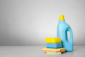 Bottle of cleaning product and supplies on light table. Space for text