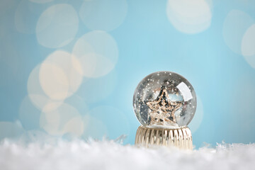 Beautiful snow globe with stars against blurred Christmas lights. Space for text