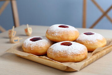 Hanukkah doughnuts with jelly and sugar powder served on wooden table, closeup