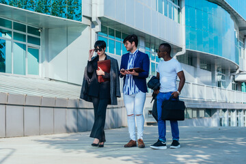 Obraz premium Businessman showing documents to his multi-ethnic co-workers in front of their big modern office building