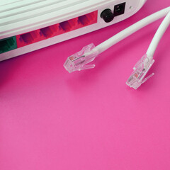 Internet router and Internet cable plugs lie on a bright pink background. Items required for...