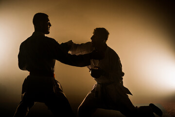 Two judoka fighter man in kimono practicing in the gym