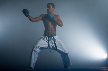 One judoka fighter man in kimono practicing in the gym