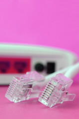 Internet router and Internet cable plugs lie on a bright pink background. Items required for...