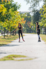Full-length picture of sexy sportswomen rollerskating in the park