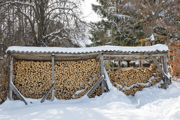 Perfectly arranged stack of wood, ready for a long winter ahead,covered in snow.Front view of...
