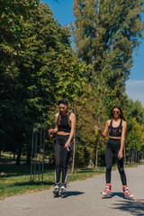 Sporty girls roller skating in park on inline skates. Female bonding.