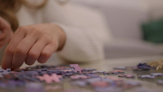 Young woman spends time with puzzles - videoclip