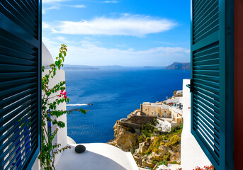 View from a window overlooking the sea, caldera and whitewashed village of Oia on the island of...