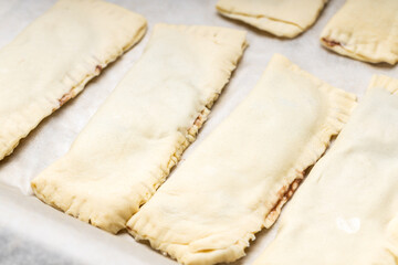 uncooked sweet pastry bun at a cooking tray. homemade cooking concept