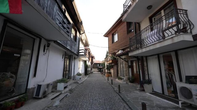 Nessebar, Bugaria - July 25, 2020: Wide angle moving shot from traditional street in Nessebar. Unique design of the houses followed by a stone path between.