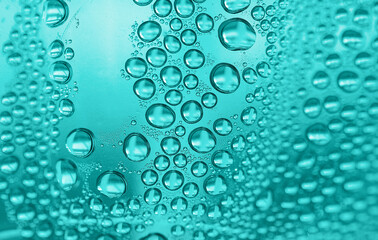 Close up water drops on light green tone background. Abstract light tidewater green wet texture with water drops on glass surface. Selective focus.