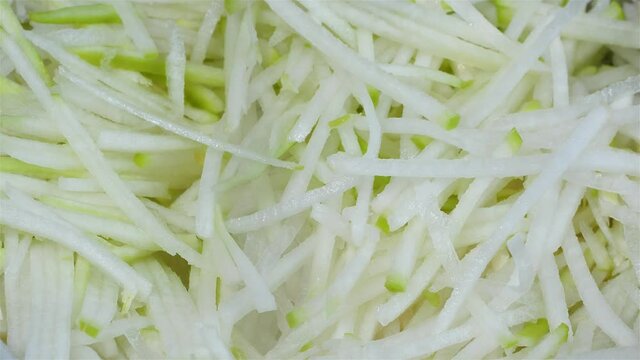 a thinly sliced korean radish in a bowl