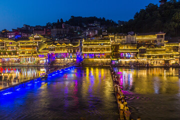 Fototapeta na wymiar Footbridge and stepping stones across Tuo river in Fenghuang Ancient Town, Hunan province, China