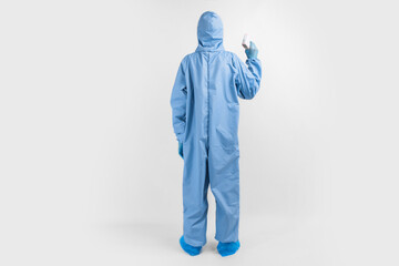 Full-length male doctor wearing protective clothing, glasses, mask and gloves, with a non-contact thermometer to measure temperature, on a white background, coronavirus epidemic concept
