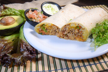 Burritos wraps with beef and vegetables on black background. Beef burrito, mexican food. Banner