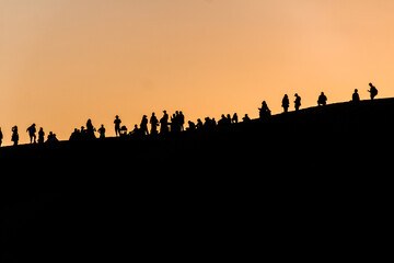 Silhouettes of tourists at Singing Sands Dune near Dunhuang, Gansu Province, China