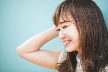 カットモデル／水色の壁の前にいる女性
