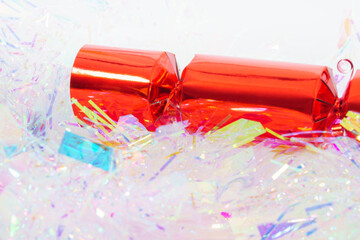 Close-up view of a festive red Christmas cracker isolated against a white background.