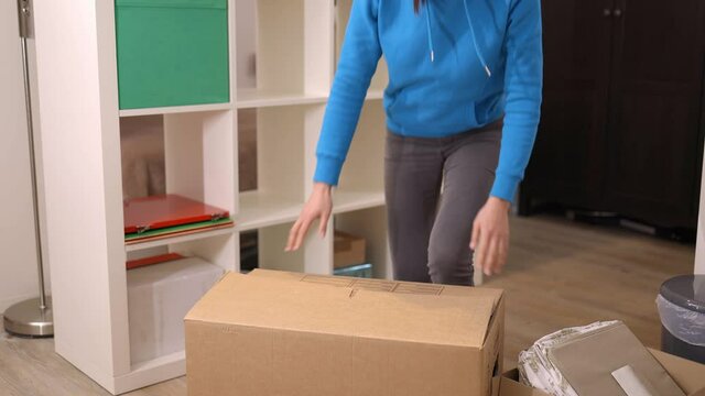 Young woman on the move carries a cardboard box - videoclip
