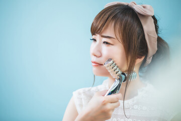 美顔ローラーでマッサージする女性
