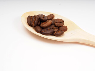 Medium roasted coffee beans on a wooden spoon, shot on a white isolated background