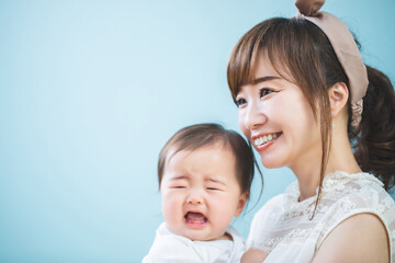 赤ちゃんを抱っこする笑顔の若いママ

