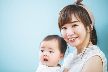 赤ちゃんを抱っこする笑顔の若いママ
