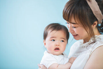 赤ちゃんを抱っこする笑顔の若いママ
