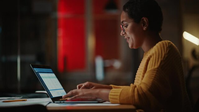 Young Multiethnic Developer Working on a Laptop Computer in Creative Office Environment. Beautiful Diverse Latin Female Project Manager is Developing Data and Scheduling a Project.