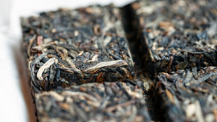Chinese raw tile-shaped Puer tea, macro picture with blurred background. 