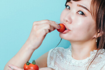 トマトを食べる女性
