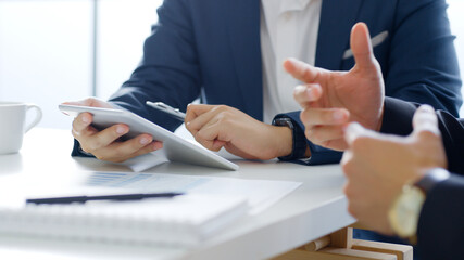 Professional businessman in suit using tablet meeting about business finance, working in office