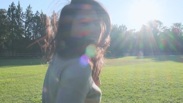 relax casual freedom asian female mature adult smiling and run with happiness and cheerful in public garden forest park with falre sunlignt