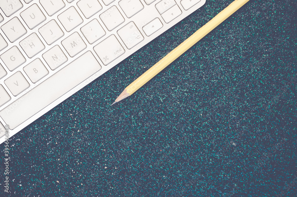Poster top view closeup of a computer keyboard and a yellow pencil on a stone textured surface