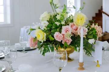 Tables set and flowers for a wedding reception. Arrangement of fresh nature flowers .