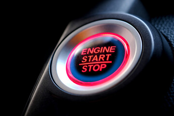 The driver's hand is pressing the car start button. Concept of transportation and technology