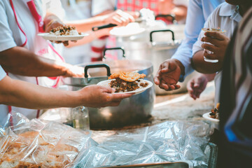 Volunteers give food to the poor: concept of charity food for the poor