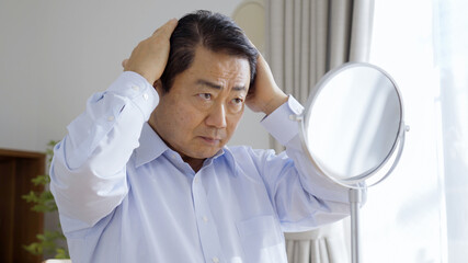 身だしなみを整える中高年男性