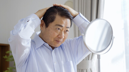 身だしなみを整える中高年男性