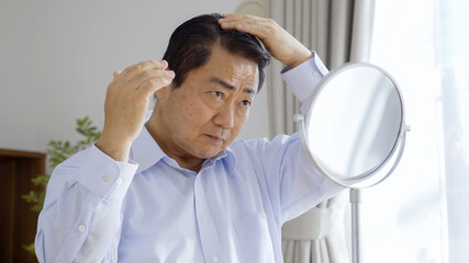 身だしなみを整える中高年男性