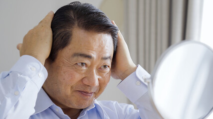 身だしなみを整える中高年男性