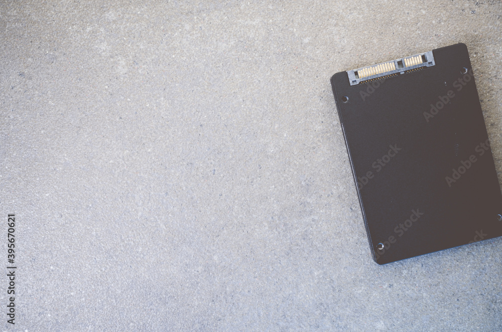 Poster top view of solid-state drive on a rough textured background with copy space