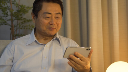 夜スマホで動画鑑賞をする中高年男性